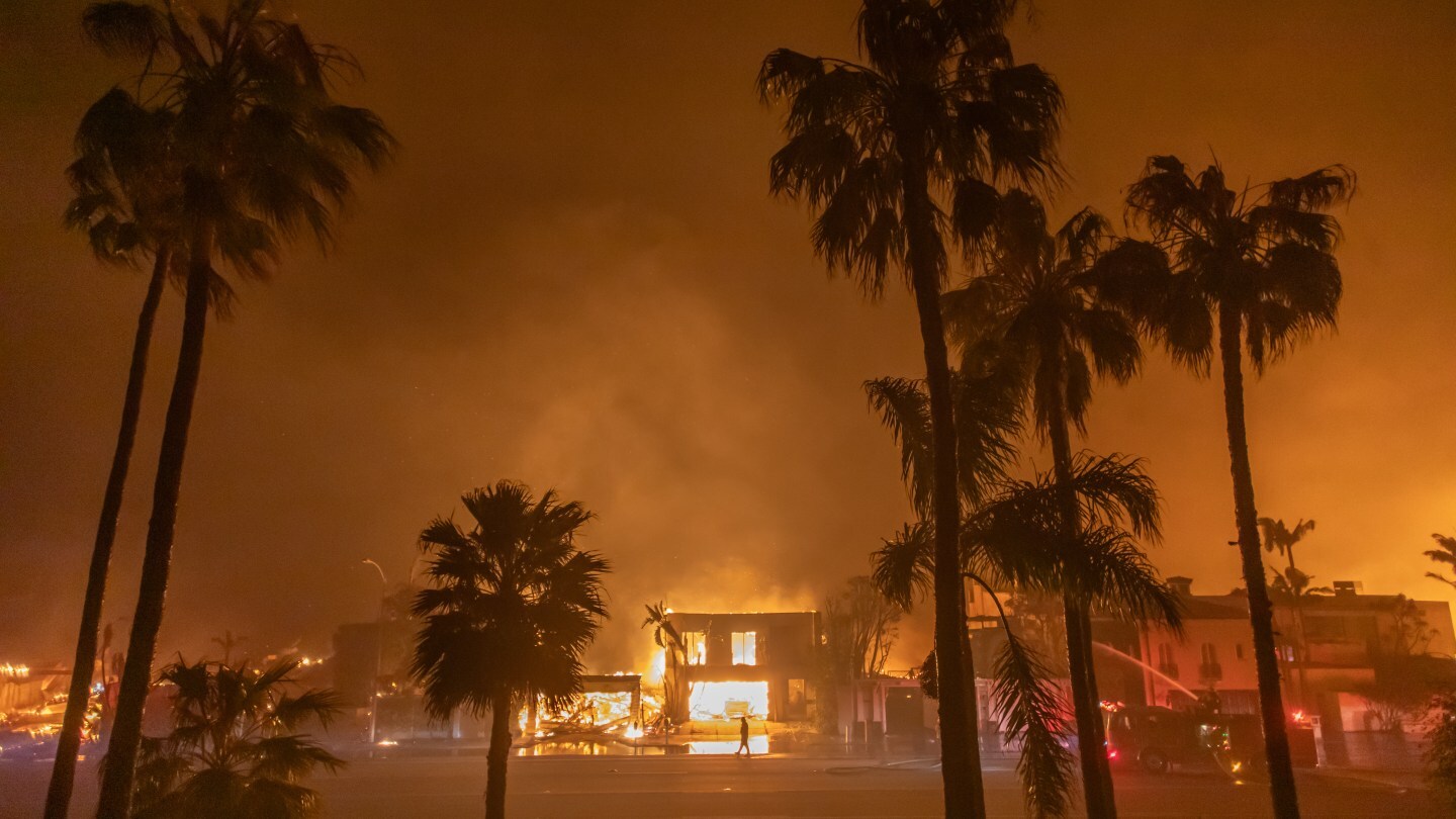 A firefighter watches the flames from the Palisades Fire burning homes on the Pacific Coast Highway amid a powerful windstorm on January 8, 2025 in Los Angeles, California. The fast-moving wildfire has grown to more than 2900-acres and is threatening homes in the coastal neighborhood amid intense Santa Ana Winds and dry conditions in Southern California.