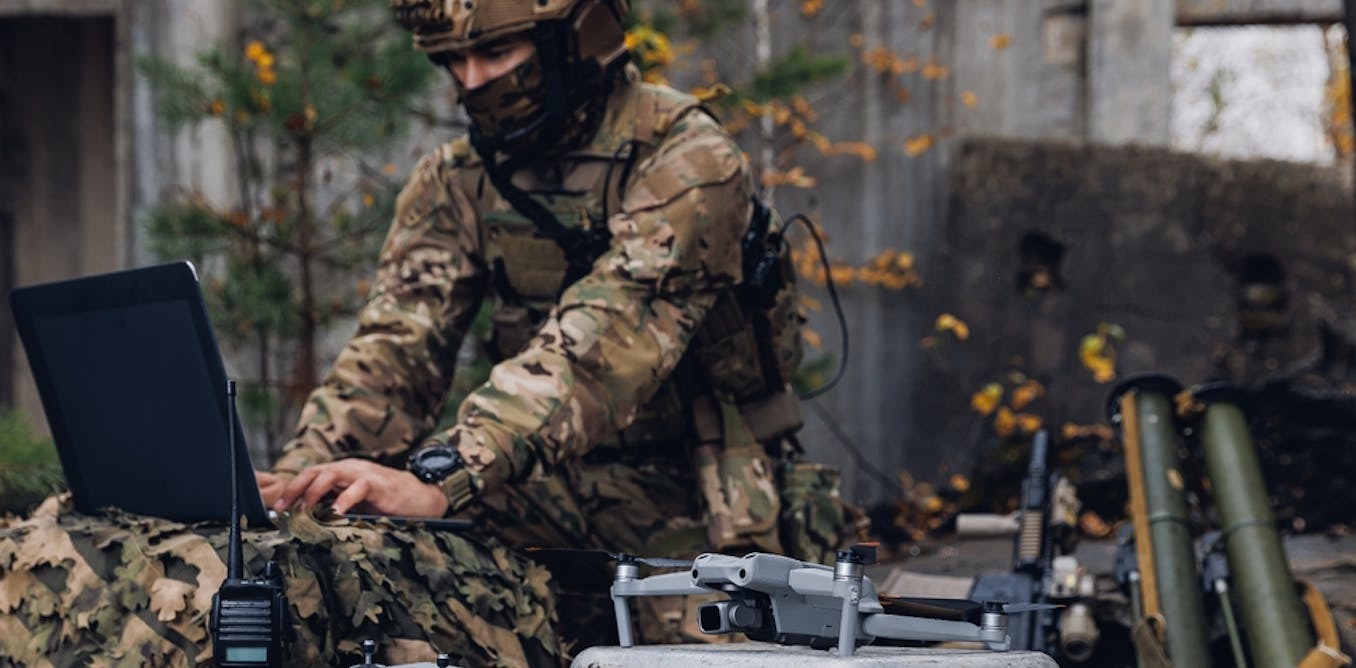 At a mobile military base, a soldier engineer transmits aerial pictures and data from a drone to artillery units. | Parilov