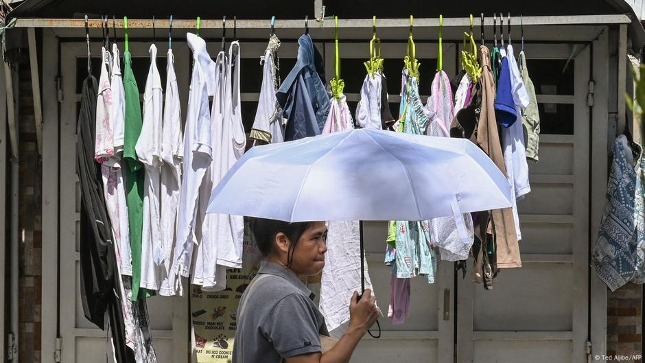 Eine Frau trägt einen Sonnenschirm, um sich gegen die Hitze zu schützen Hitzewelle in Manila – Schulschließungen wegen extremer Temperaturen