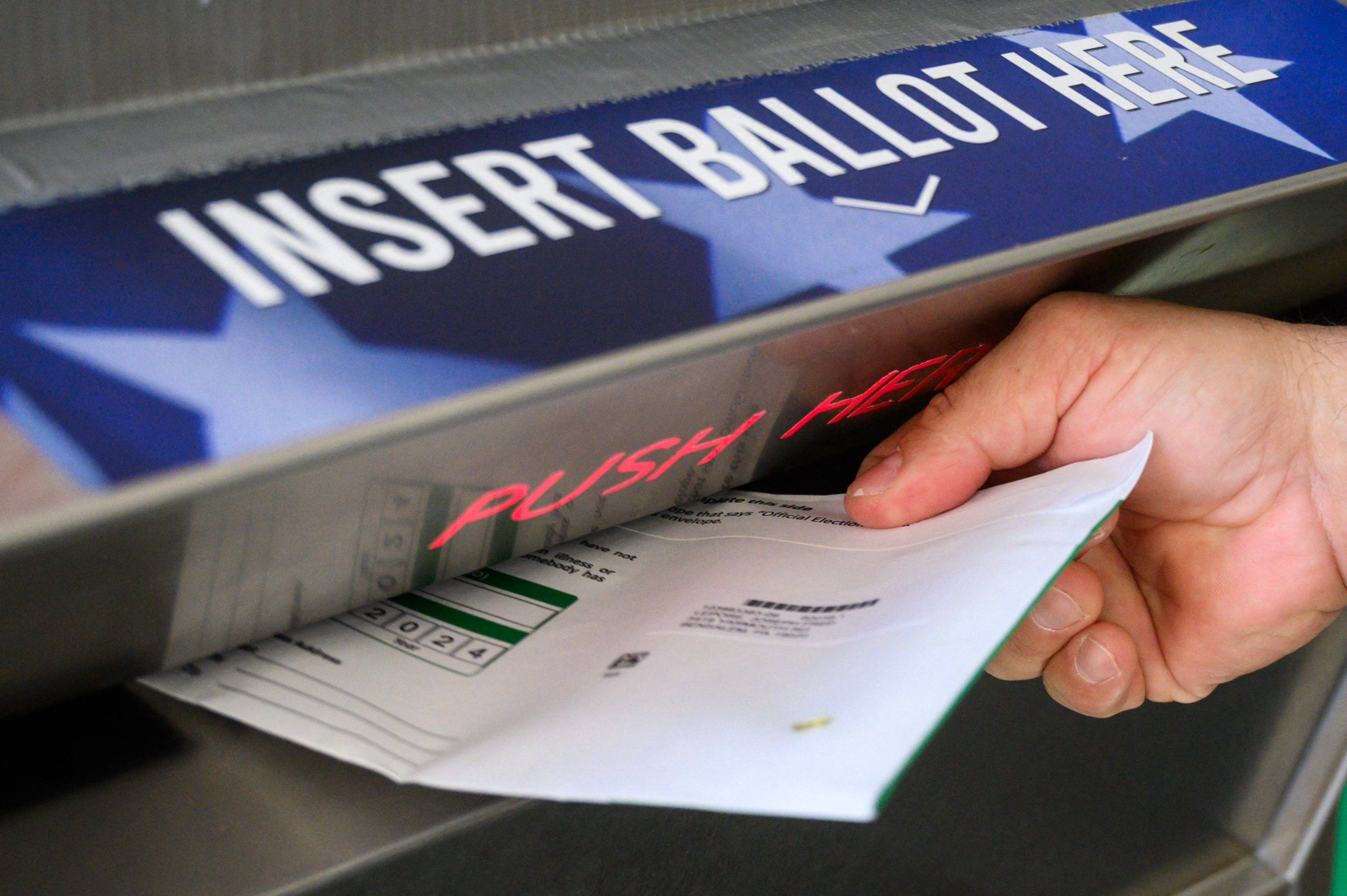 A voter uses a ballot drop box