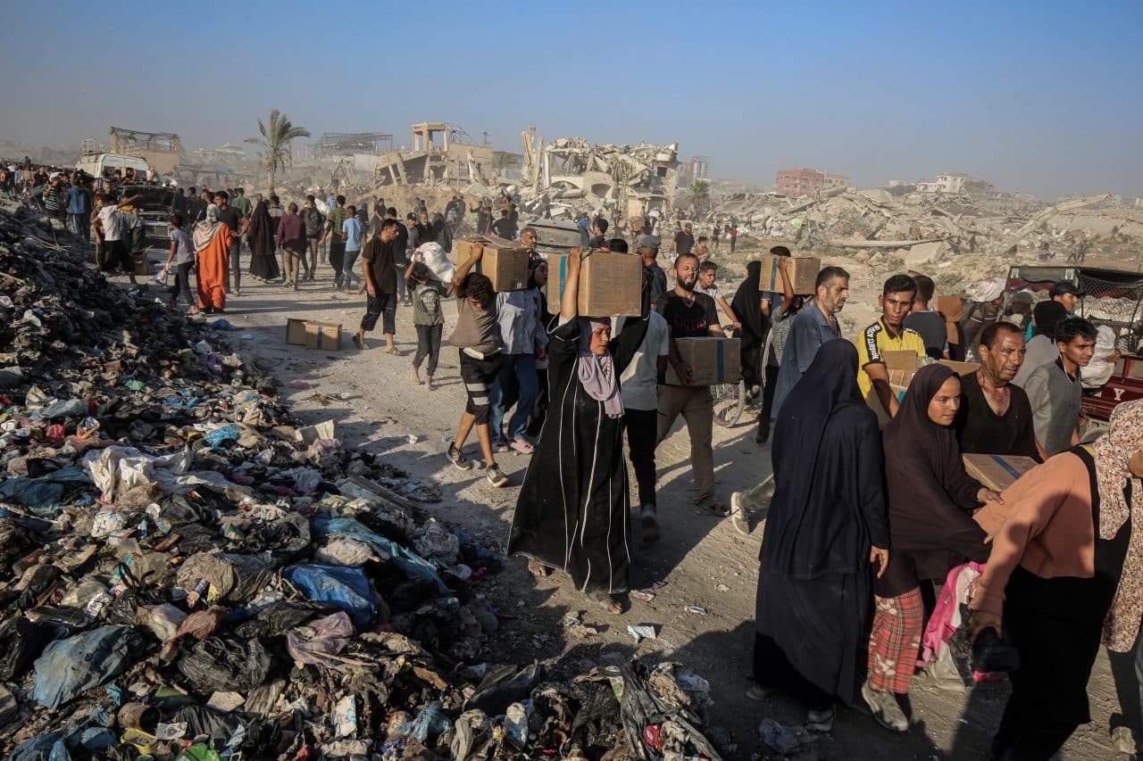 Palestinians carry food parcels distributed by Gaza Humanitarian Foundation, June 16, 2025. (Photo: Omar Ashtawy/APA Images)