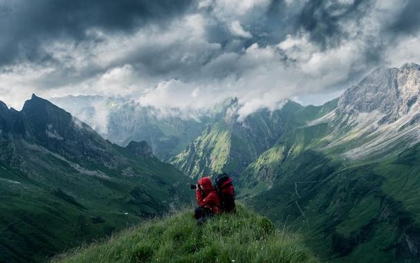 Woman sitting on a mountain under a cloudy sky imported using WordPress External Images Plugin