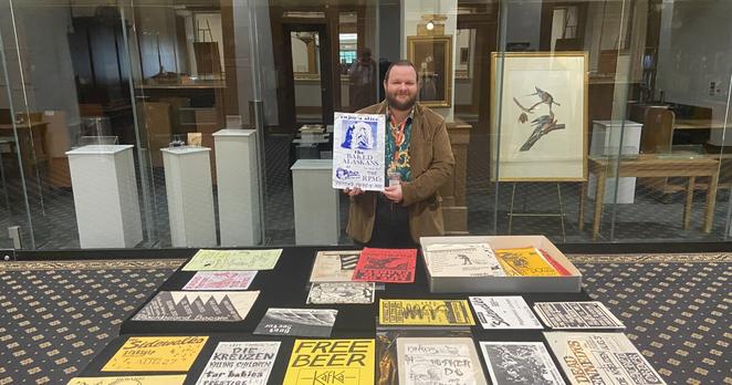 MPL Rare Books Librarian Timothy Rush shows of the library's poster collection.