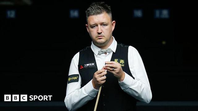 Kyren Wilson chalking his cue