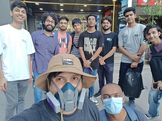 A selfie of the ten male participants, smiling as they stand in front of some shops.